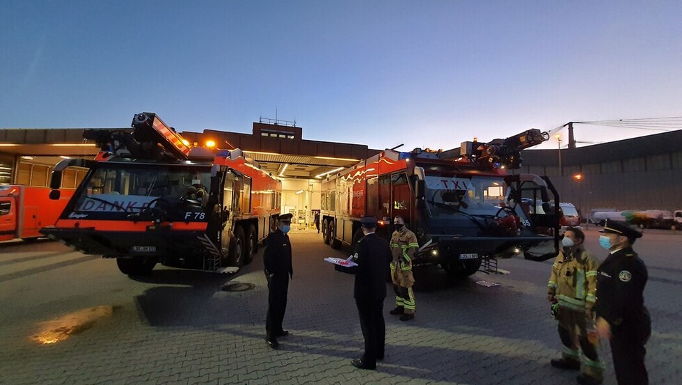 Kräfte der Flughafenfeuerwehr und der Berliner Feuerwehr vor zwei Flugfeldlöschfahrzuegen