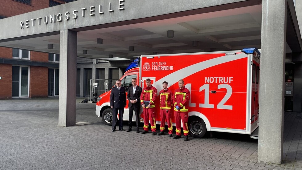 Dr. Karsten Homrighausen, Dr. Johannes Danckert und Rettungswagenbesatzung vor einem Rettungswagen an der Notaufnahme