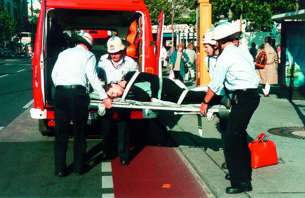 Feuerwhrleute bringen einen Mann auf einer Trage in den Rettungswagen