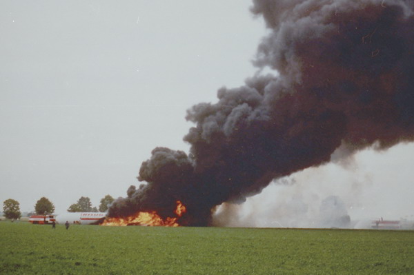 Brennendes Flugzeug auf Feld, Rauchsäule