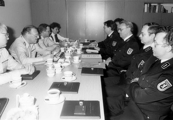 Personen in Feuerwehruniformen an einem Konferenztisch