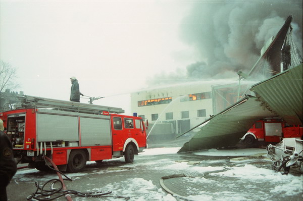 Löschfahrzeug, brennende Halle im Hintergrund