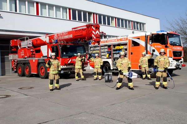 Feuerwehrleute mit Fahrzeugen vor Wache