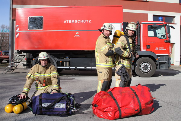 Feuerwehrleute mit Ausrüstung vor Gerätewagen