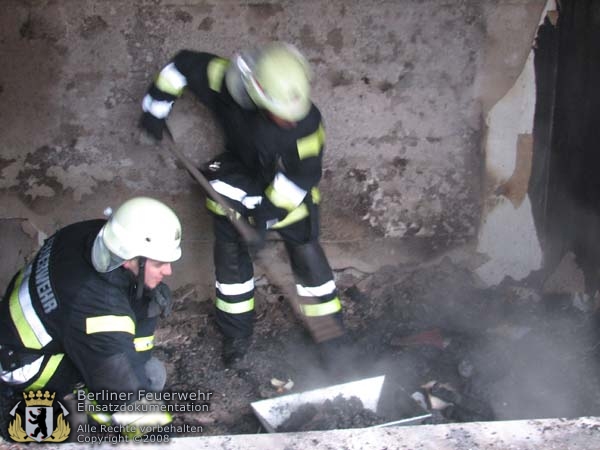 Feuerwehrleute arbeiten im Brandschutt