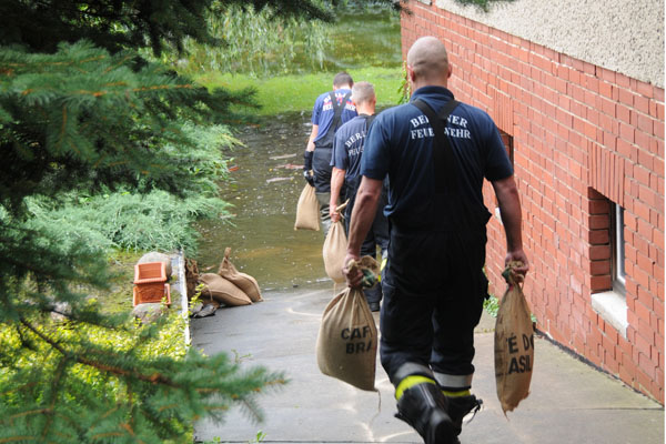 Feuerwehrmann mit Sandsäcken