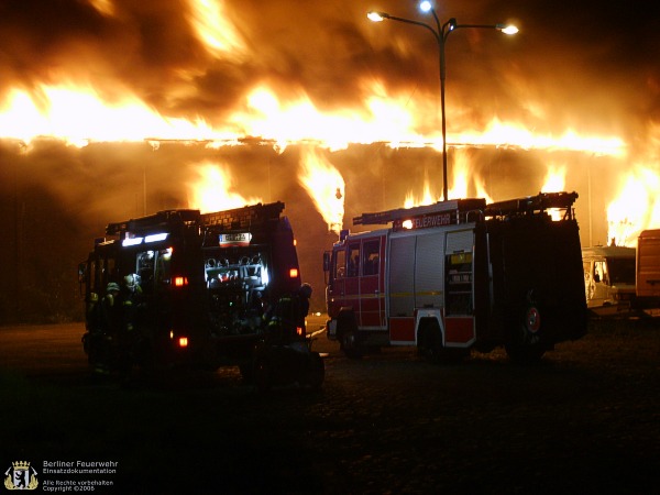 Fahrzeuge vor dem brennenden Gebäude