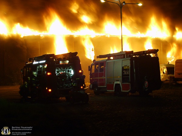 Fahrzeuge vor dem brennenden Gebäude