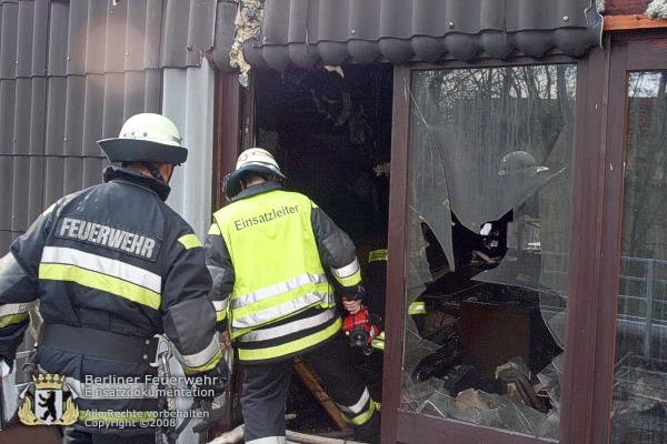 Feuerwehrleute an zerstörtem Fenster