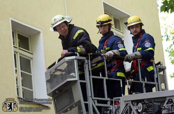 Feuerwehrmann und THW-Leute im Leiterkorb
