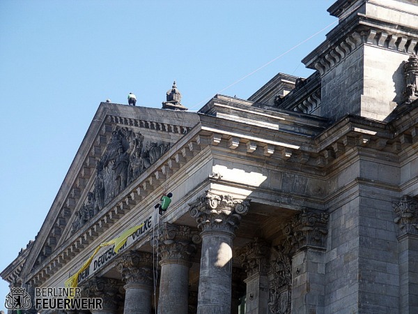 Person hängt am Reichstagsgebäude