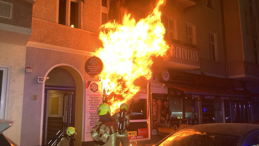 Hohe Flammen schlagen aus dem Laden in der Greifswalder Straße