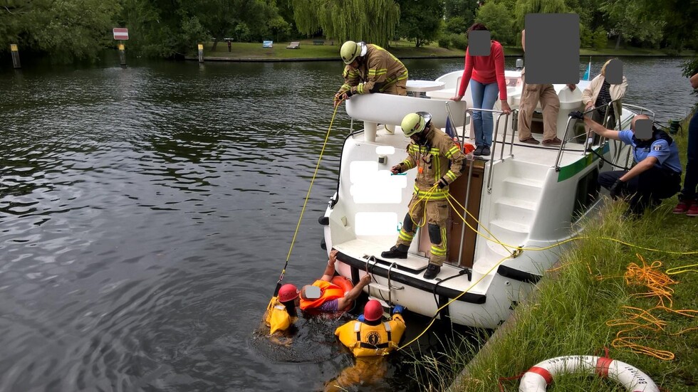 Einsatzkräfte halten Person über Wasser