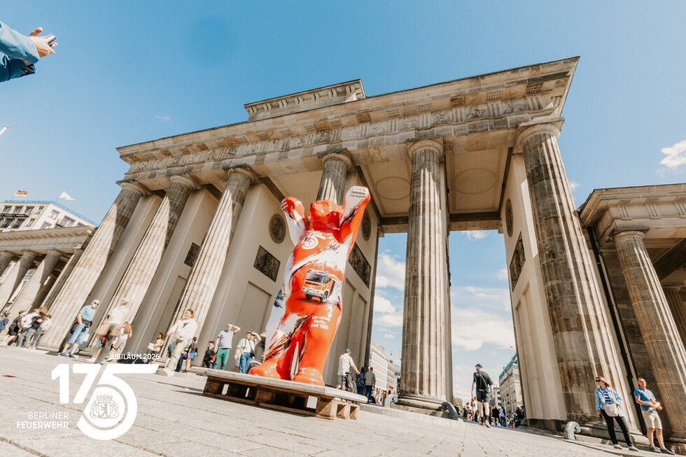 Der Buddy Bär der Berliner Feuerwehr begrüßt die Zuschauerinnen und Zuschauer am Brandenburger Tor.