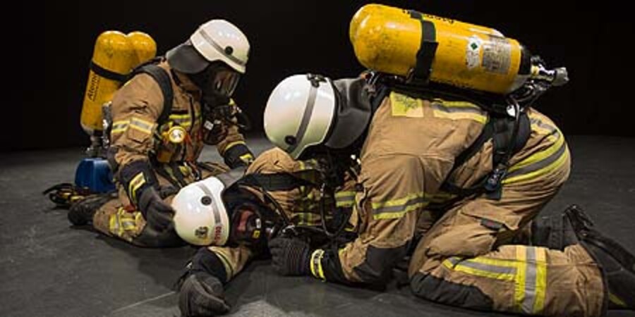 Drei Feuerwehrleute üben für den Notfall