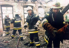 Feuerwehrleute in ausgebranntem Gebäude