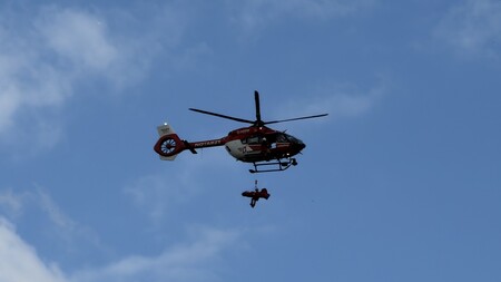 Verletzter im Bergesack mit Notarzt unterhalb des Rettungshubschrauber