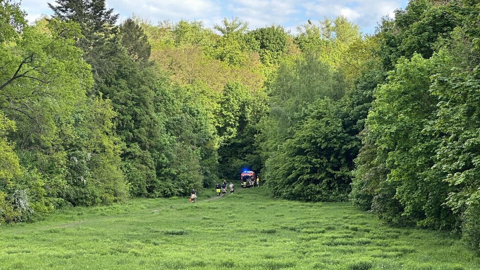 Einsatzkräfte kommen mit dem Equipment aus dem schwer zugänglichen Gelände zurück