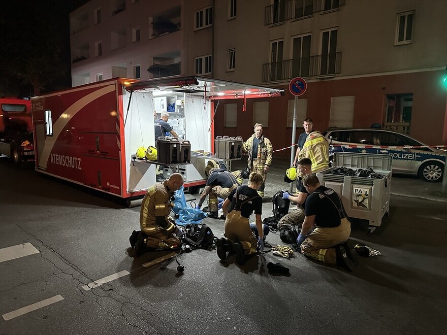 Einsatzkräfte tauschen Pressluftatmer am AB-Atemschutz.