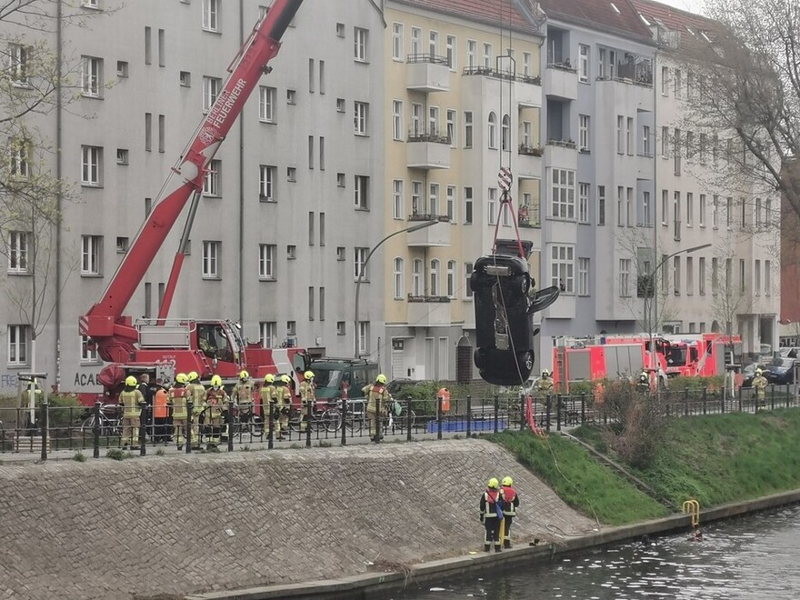 PKW wird mit dem Feuerwehrkran aus dem Wasser gehoben.