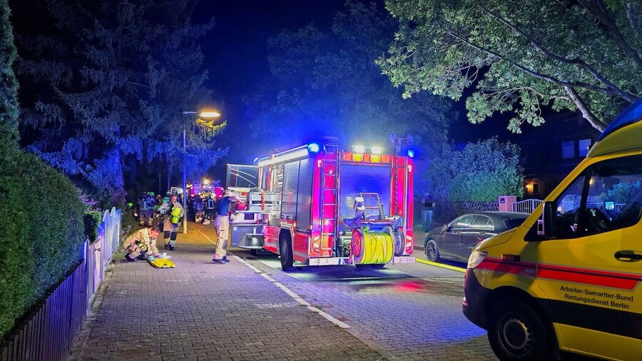 Lösch-Hilfeleistungs-Fahrzeug an der Einsatzstelle mit Einsatzkräften bei Aufräumarbeiten. 