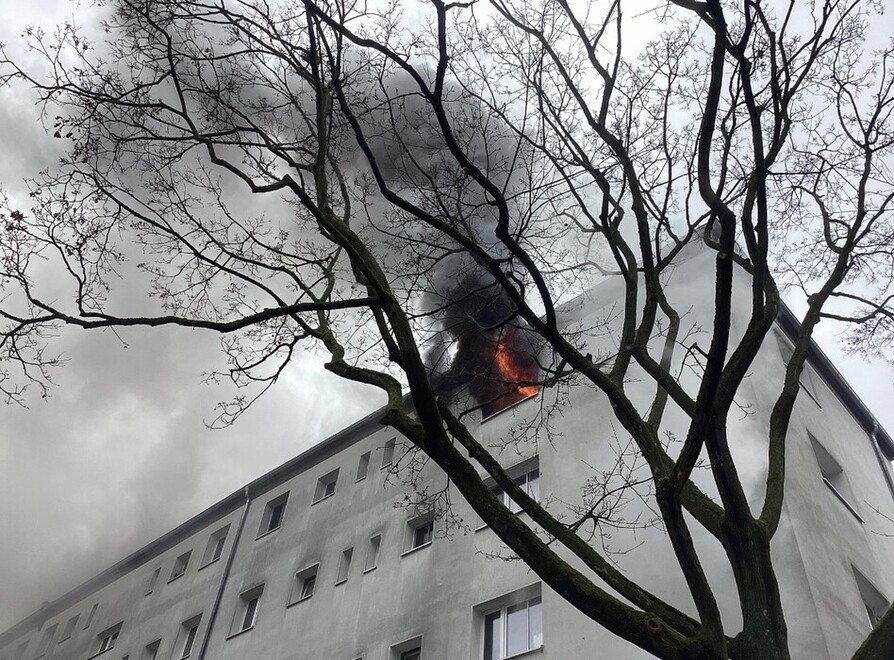 Flammen und Rauch aus einem Fenster der Wohnung. 
