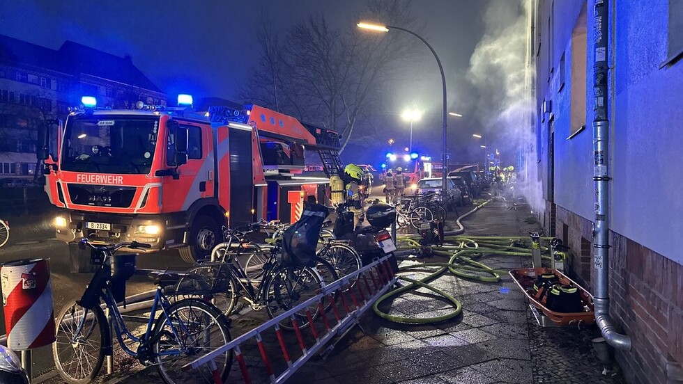 Drehleiter und weitere Fahrzeuge sowie Einsatzkräfte vor der Einsatzstelle