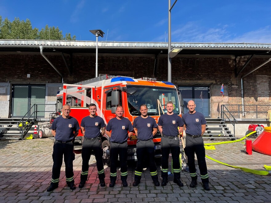 Löschfahrzeug mit Feuerwehrleuten der Lehrfeuerwache