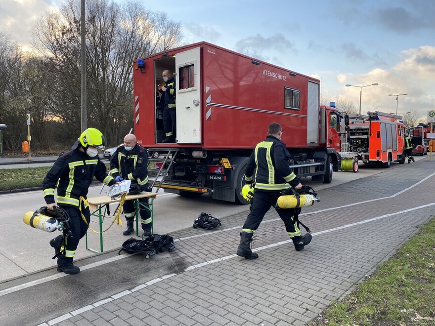 Einsatzkräfte tauschen Atemschutzgeräte am AB Atemschutz