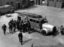 Feuerwehrleute mit Einsatzfahrzeug 