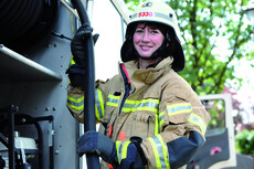 Feuerwehrfrau mit Helm und Einsatzkleidung