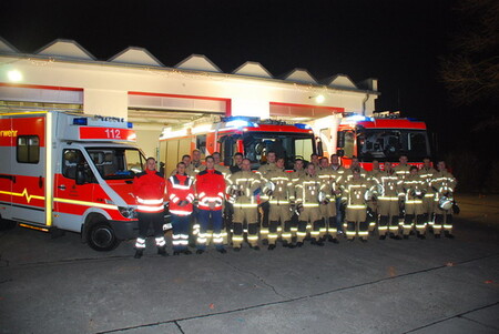 Feuerwehrleute vor Wache bei Nacht