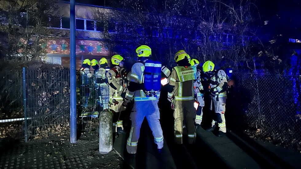 Einsatzkräfte vor dem Brandgebäude