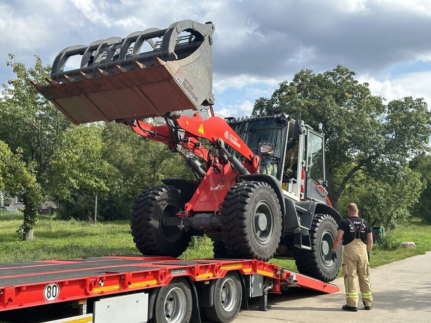 Radlader wird vom Feuerwehranhänger Tieflader gefahren