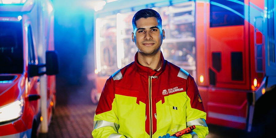 Notfallsanitäter steht vor Einsatzfahrzeugen