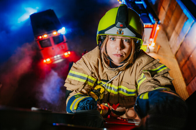 Platzhalter: Feuerwehrfrau in PBI auf einer Leiter