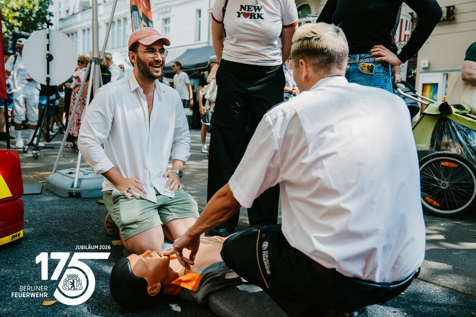 Mitarbeitende der Berliner Feuerwehr zeigen Besucherinnen und Besuchern die Grundlagen der Herzdruckmassage.
