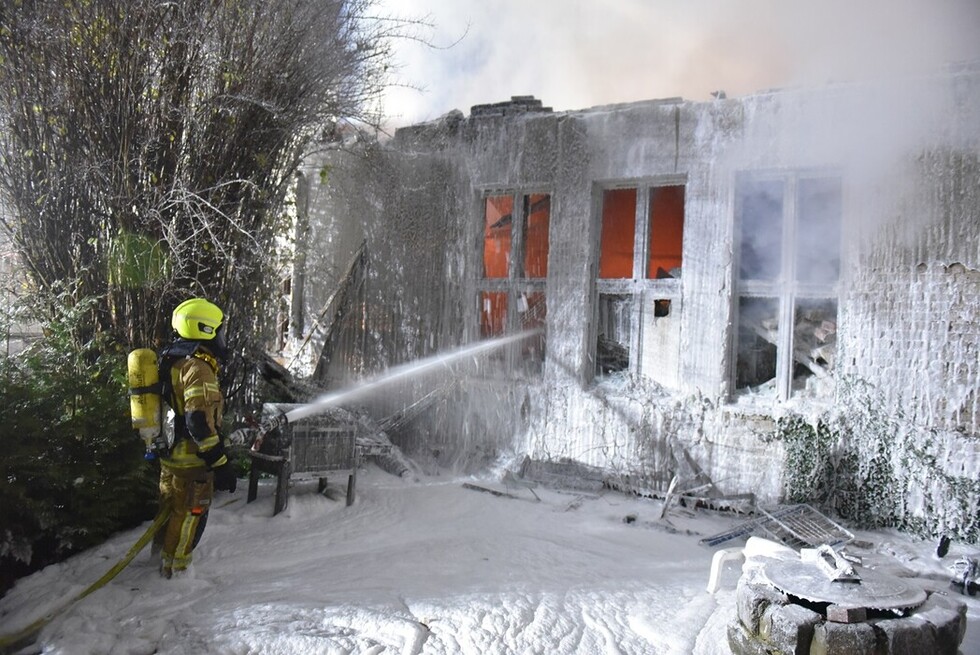 Einsatzkraft löscht den Brand mit einem C-Rohr