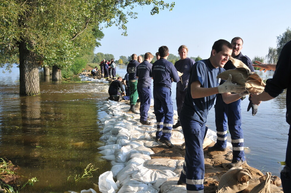 Hochwassereinsatz, Feuerwehrleute sichern einen Deich mit Sandsäcken