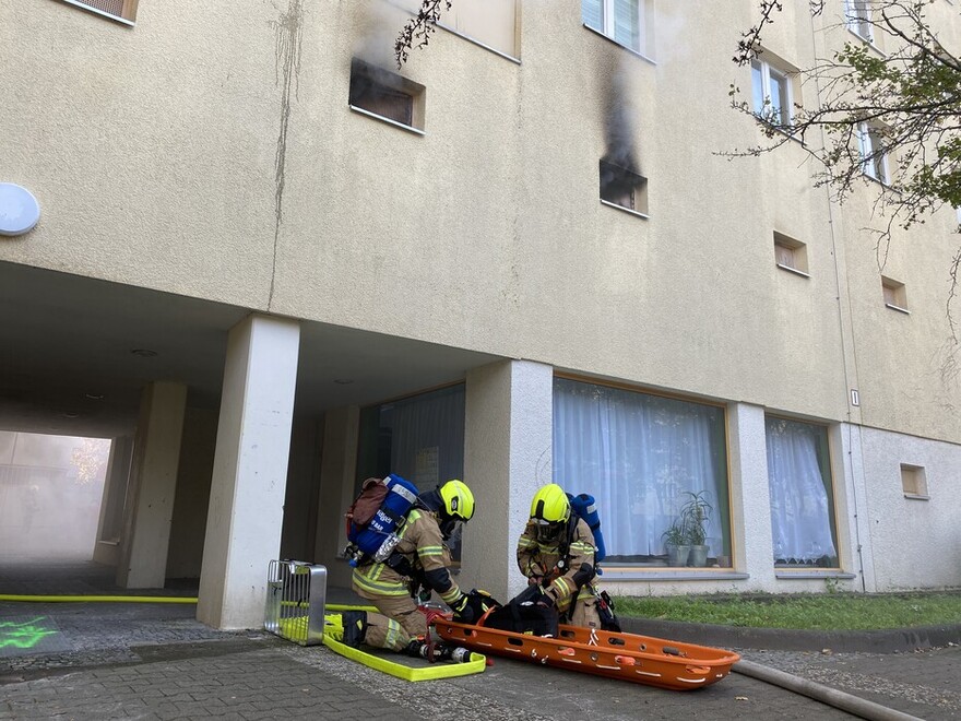 Sicherheitstrupp und sichtbarer Brandrauch aus dem Hochkeller