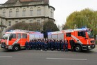 Mitglieder der Freiwilligen Feuerwehr und der Jugendfeuerwehr Treptow aufgestellt vor zwei Lösch- und Hilfeleistungsfahrzeugen.