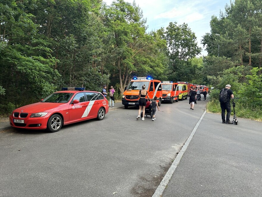 Einsatzfahrzeuge und Fahrgäste neben der Bahnstrecke in Nähe des FEZ