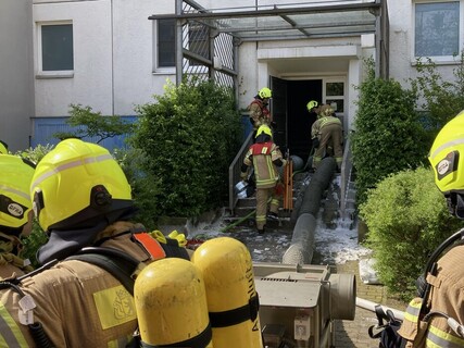 Einsatzkräfte mit Spezialtechnik vor Brandobjekt