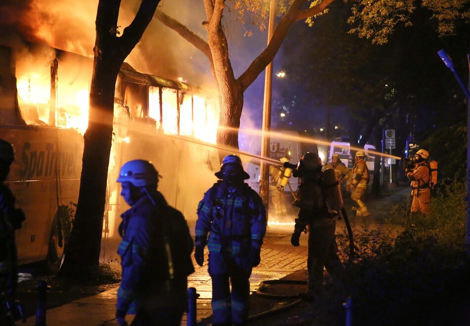 Einsatzkräfte beim Löschen eines Busses