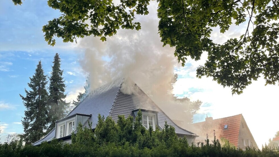 Rauch steigt aus dem Dach des betroffenen Hauses auf.