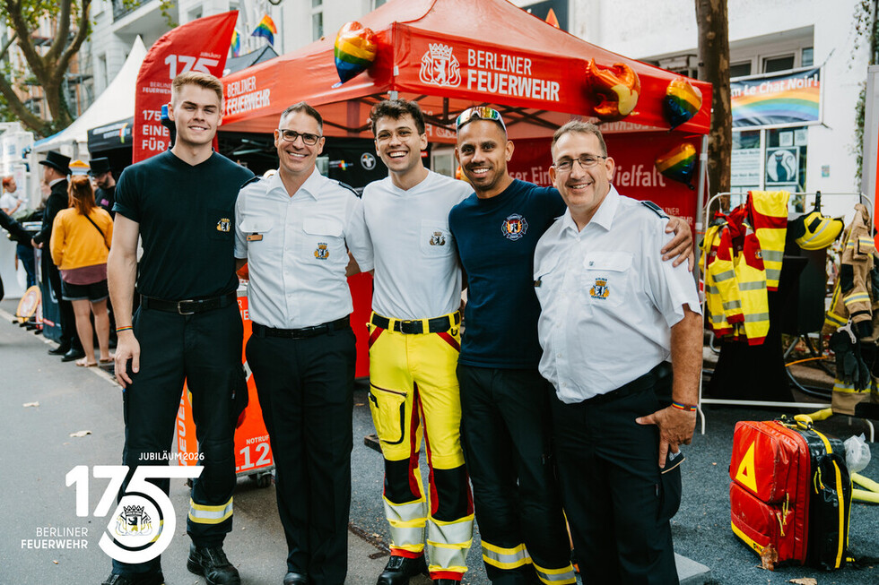 Gruppenfoto der Mitarbeitenden der Berliner Feuerwehr am Informationsstand der Berliner Feuerwehr.