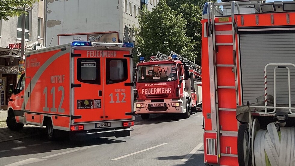 Eine Drehleiter wird in Stellung gebracht, davor ein Rettungswagen. 
