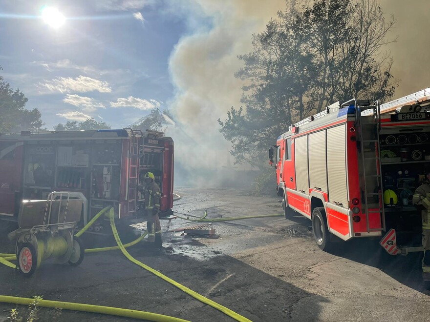 Löschfahrzeuge vor der ausgebrannten Halle