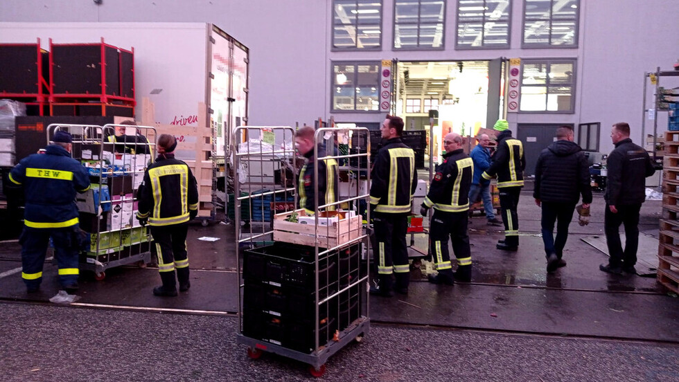 Ehrenamtliche Helfer laden Obst und Gemüse auf Lkw.