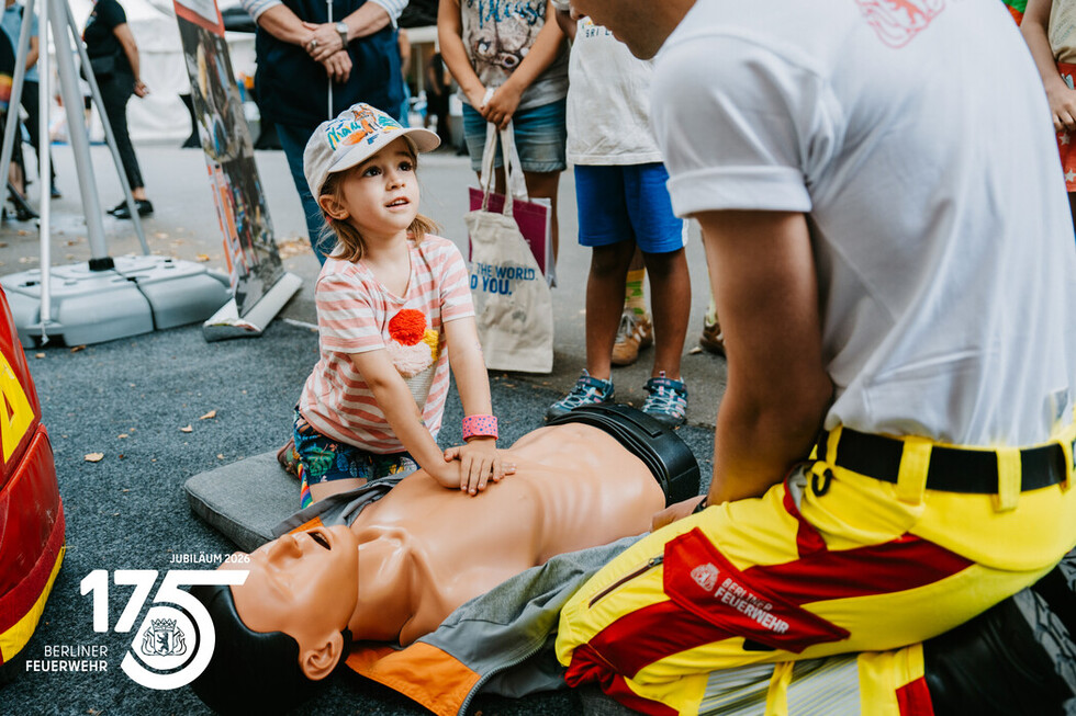 Mitarbeitende der Berliner Feuerwehr zeigen Besucherinnen und Besuchern die Grundlagen der Herzdruckmassage.